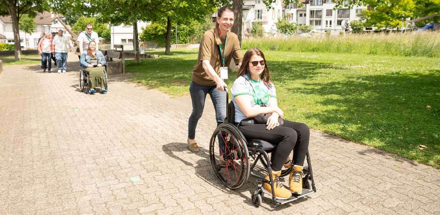 Personen mit und ohne Rollstuhl in einem Park Personen mit und ohne Rollstuhl in einem Park
