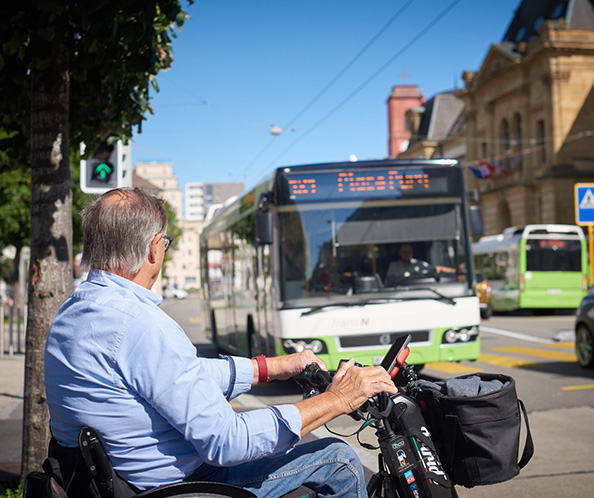 Un uomo in sedia a rotelle aspetta l'autobus