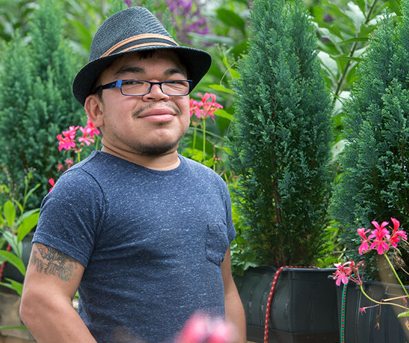 Ragazzo con cappello in un giardino