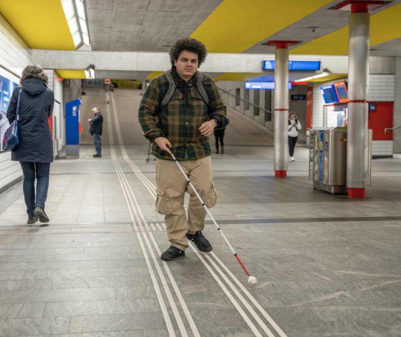 Un homme malvoyant se déplace dans une gare