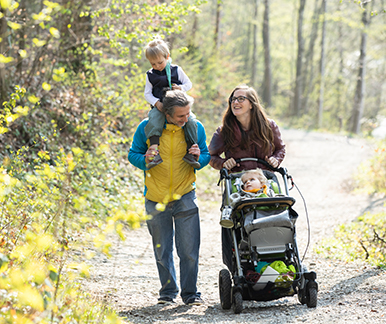 Familie mit gesundem und behindertem Sohn spaziert im Wald
